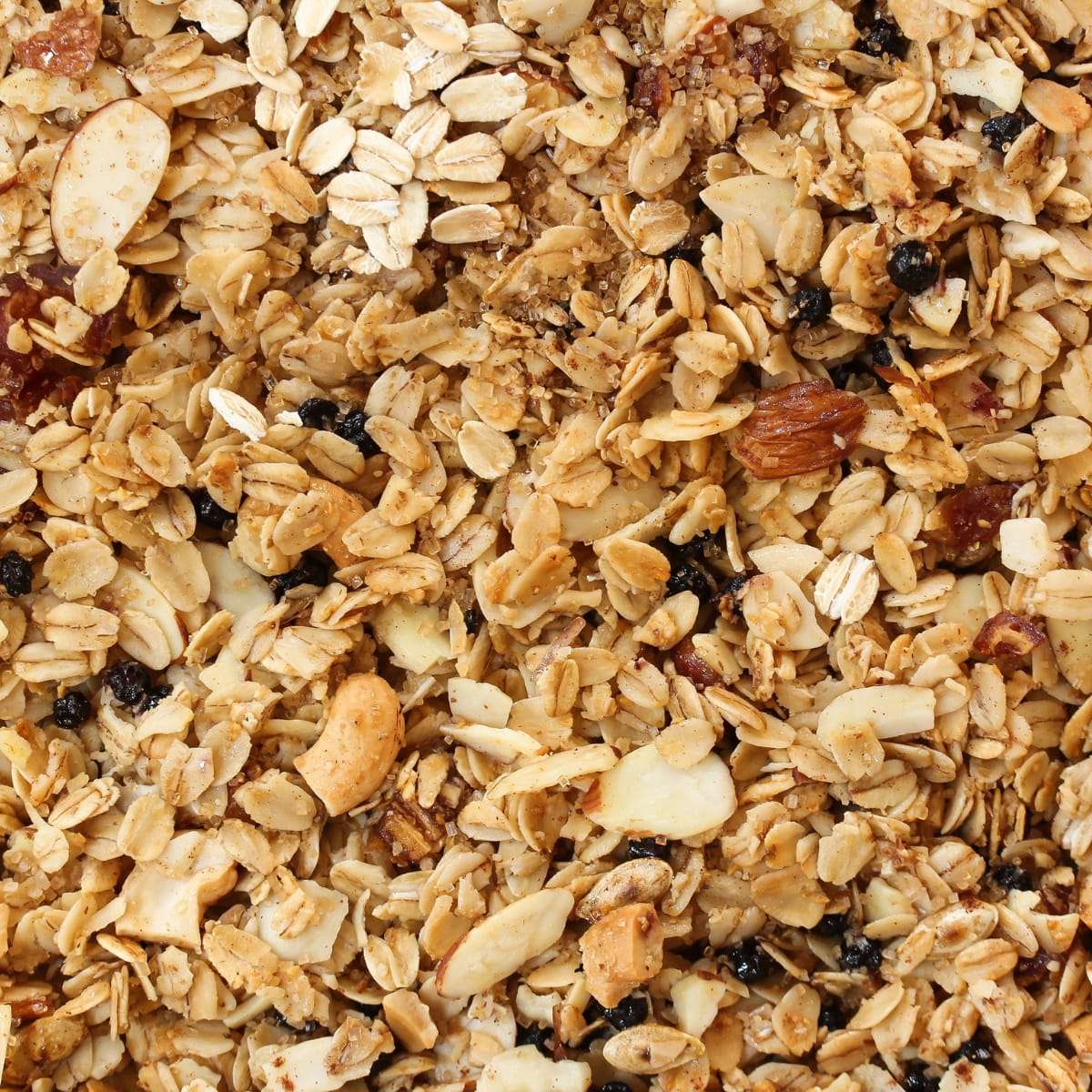 Close-up of golden homemade granola with oats, sliced almonds and dried berries