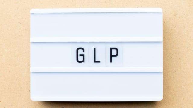 A lightbox sign spelling out "GLP" on a tan background