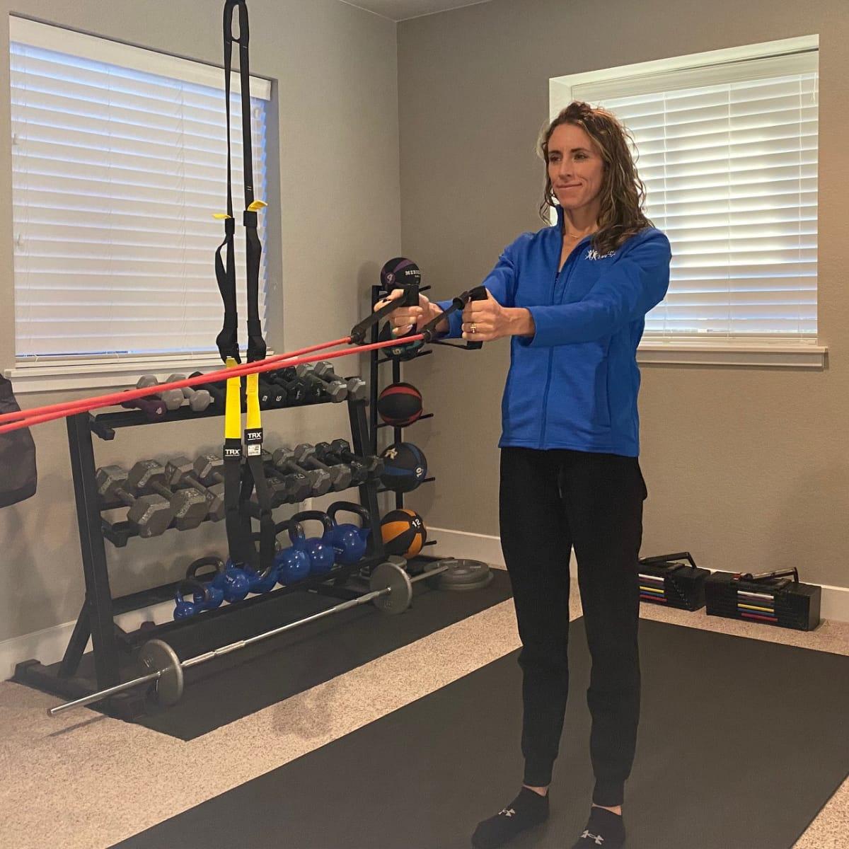 Facing an anchored resistance band with both arms extended forward, holding one handle in each hand