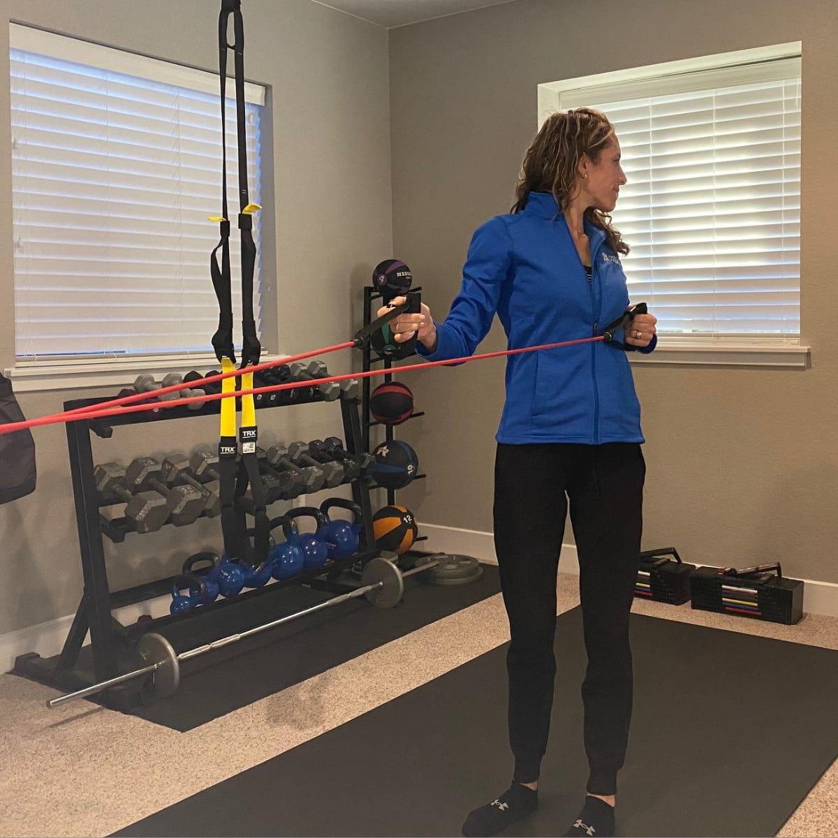 Rowing one handle back toward the torso while rotating the upper body to that side