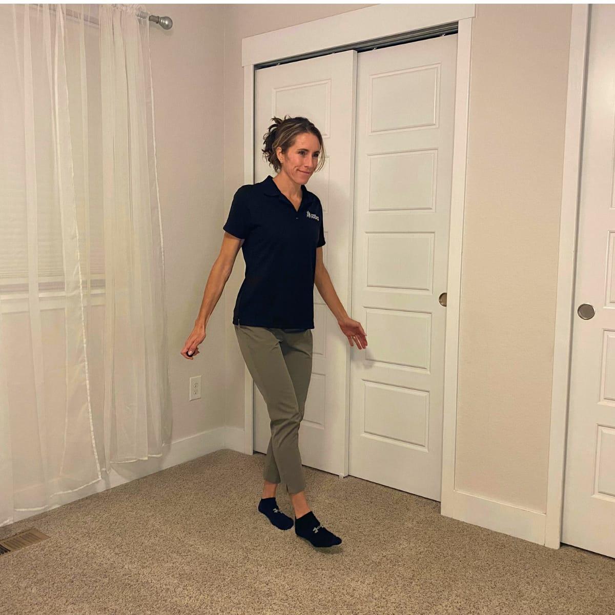 A trainer walking forward placing one heel directly in front of the other foot's toes
