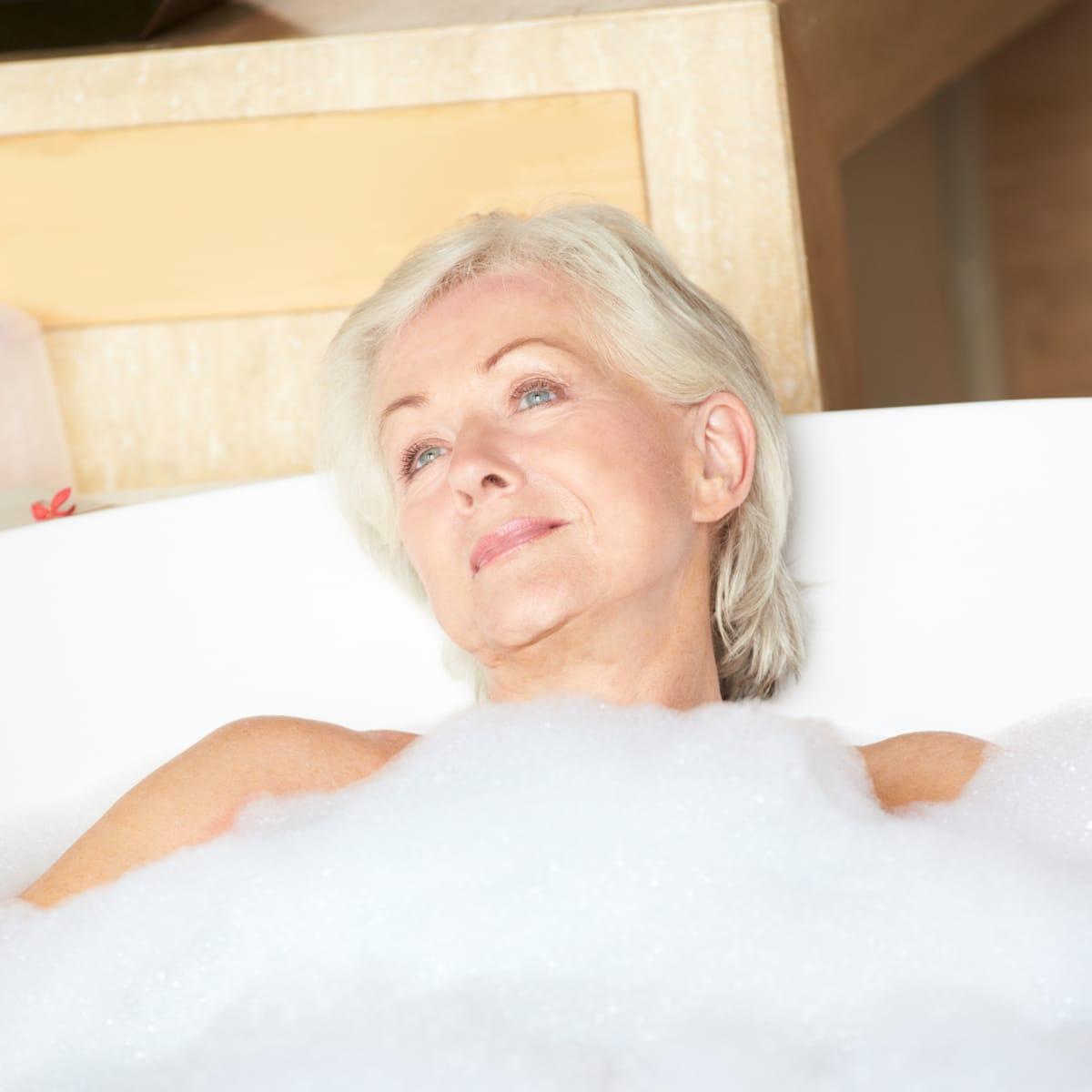 An older woman relaxing in a bubble bath
