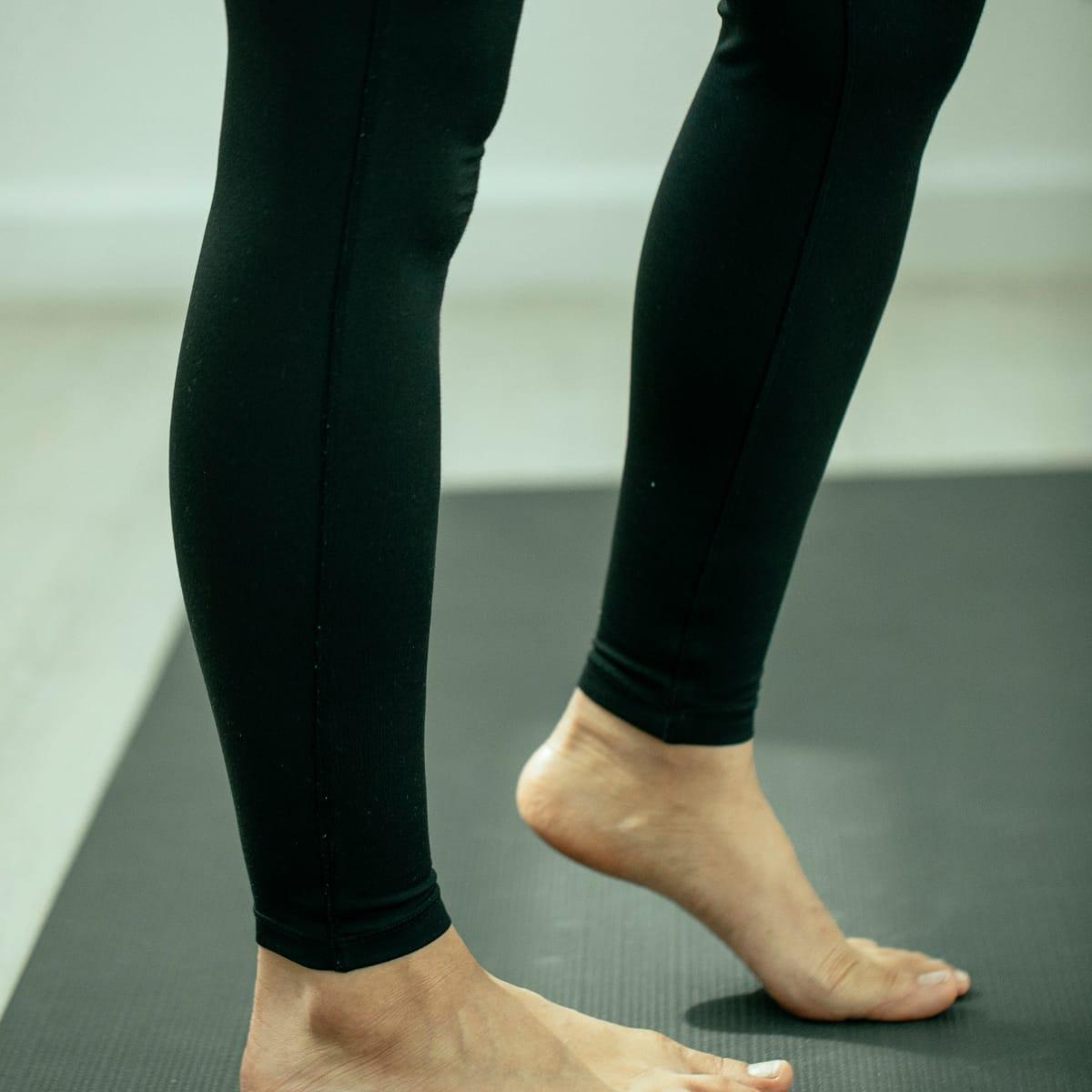 Bare feet on an exercise mat, one heel lifted in a balance drill